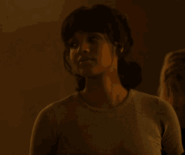 a woman in a grey t-shirt looks up at something
