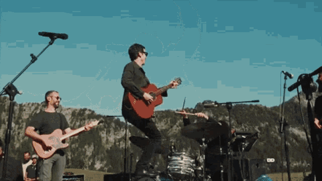 a man is jumping in the air while playing guitar
