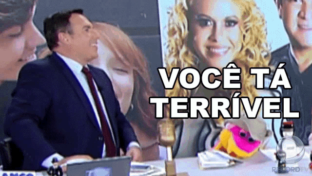 a man in a suit and tie stands in front of a picture of a woman and the words voce ta terrivel