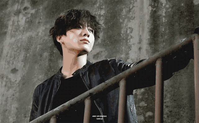 a young man in a black jacket leans against a railing with the words army of dynamite written on the bottom