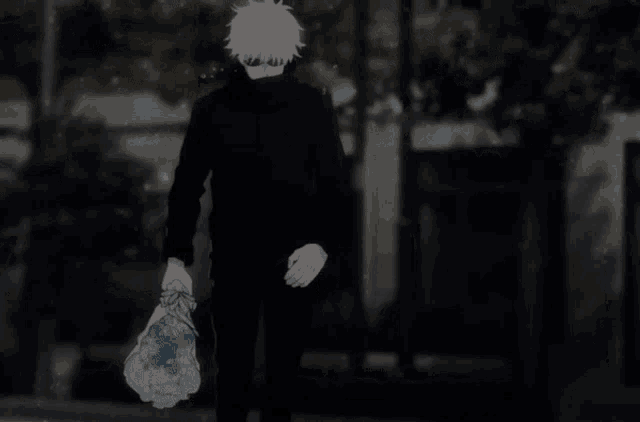 a man in a black coat is holding a bag