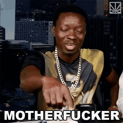 a man with a gold chain around his neck is pointing at something and says motherfucker