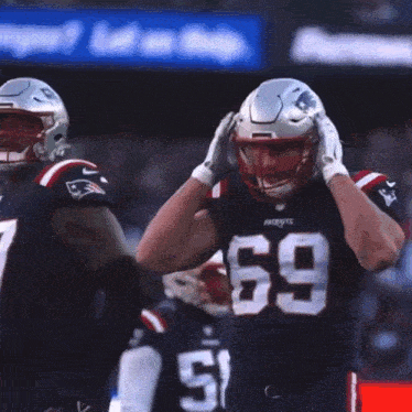 a patriots football player wearing number 69 adjusts his helmet during a game