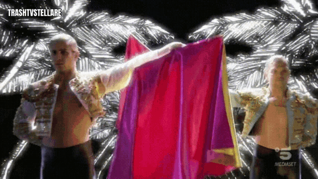 a man holding a pink and purple cloth with the number 5 on the bottom