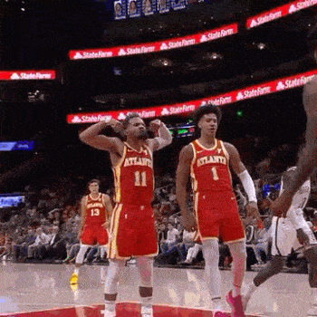 a couple of basketball players are standing on a basketball court .