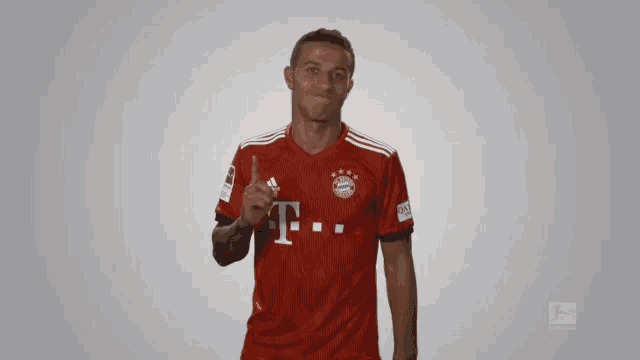 a man wearing a red t-mobile shirt giving a thumbs up
