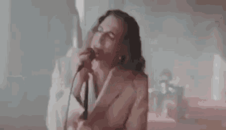 a man is singing into a microphone with the words marlena torna a casa .