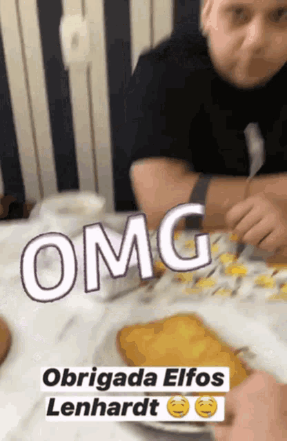 a man sits at a table with a plate of food and a sticker that says " omg "