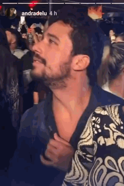 a man with a tattoo on his neck is standing in a crowd with andradelu written on the bottom