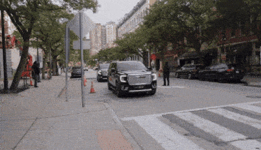 a black gmc suv is driving down a street