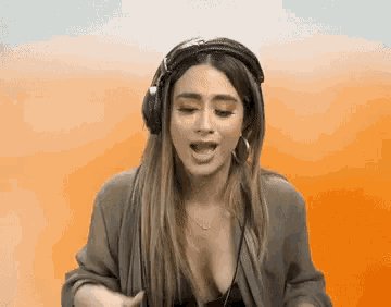 a woman wearing headphones is singing into a microphone
