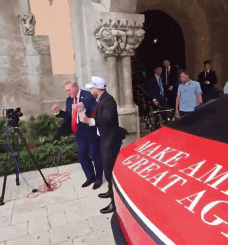 a red car that says make america great again on the side