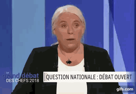 a woman is standing in front of a sign that says " question nationale " on it