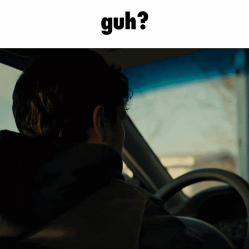 a man is driving a car and the word guh is on the bottom