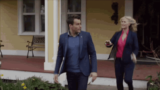 a man and a woman are walking on a porch