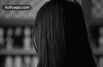 a black and white photo of a woman 's head with long hair .