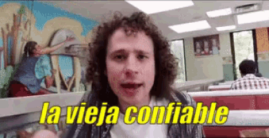 a man with curly hair is sitting in a diner and says la vieja confiable .