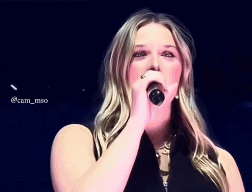 a woman singing into a microphone with the hashtag @cam_mso on the bottom