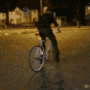 a person is riding a bicycle on a street at night