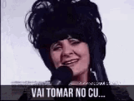 a woman wearing headphones is talking into a microphone and says vai tomar no cu .