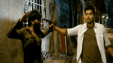 a man is pointing a gun at another man in a scene from a movie written by numeshuja