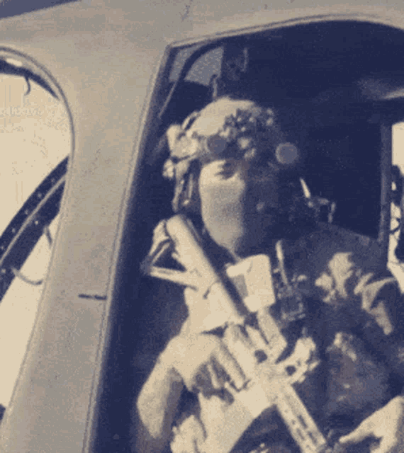 a man wearing a helmet and goggles is holding a rifle