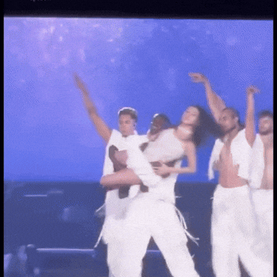 a man is carrying a woman on his shoulders on a stage .