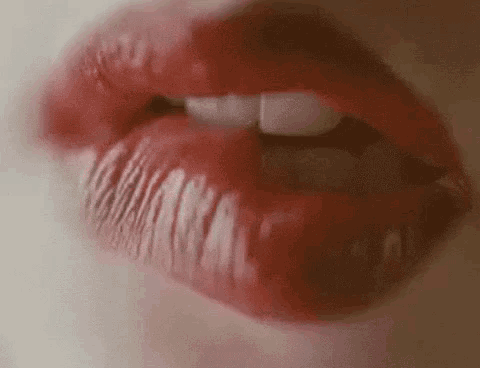 a close up of a woman 's lips with red lipstick on .