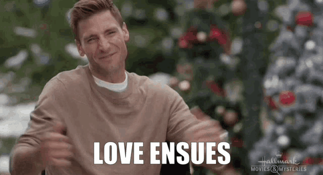 a man says love ensues in front of a christmas tree .
