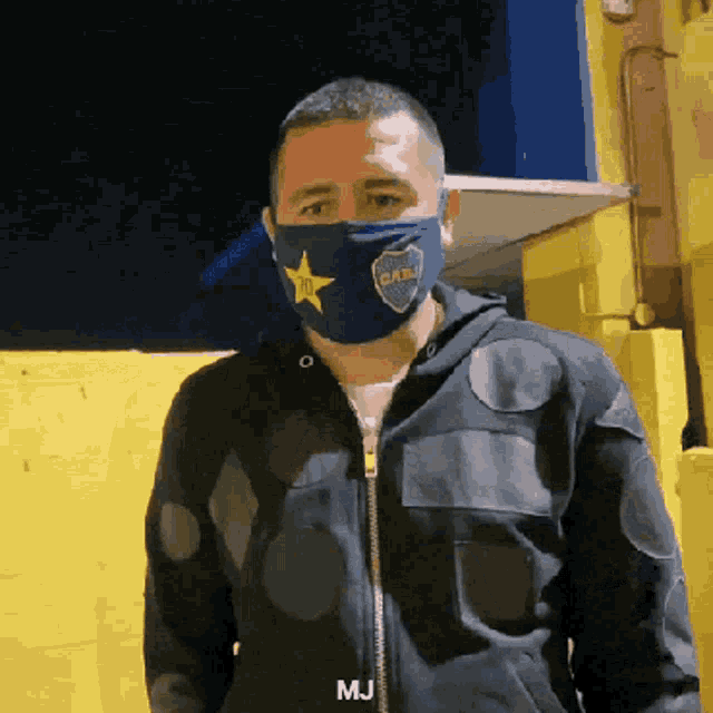 a man wearing a face mask with a cabj logo on it