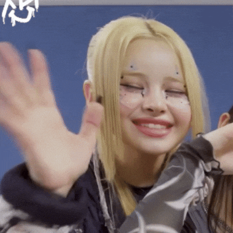a woman with blonde hair is smiling with her eyes closed
