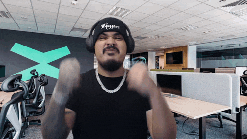 a man wearing headphones and a beanie that says ' buzzard ' on it