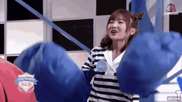 a girl wearing a striped shirt with a victory bnk48 logo