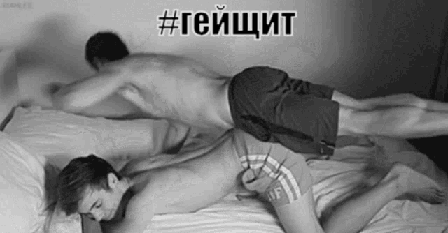 a black and white photo of two men laying on a bed with the hashtag #гейщит