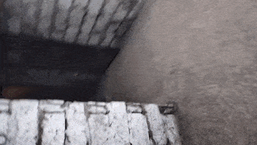 a person is walking down a set of stairs with a brick wall behind them .