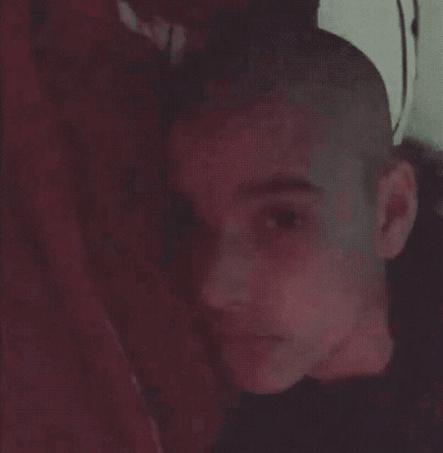 a man with a shaved head is making a funny face