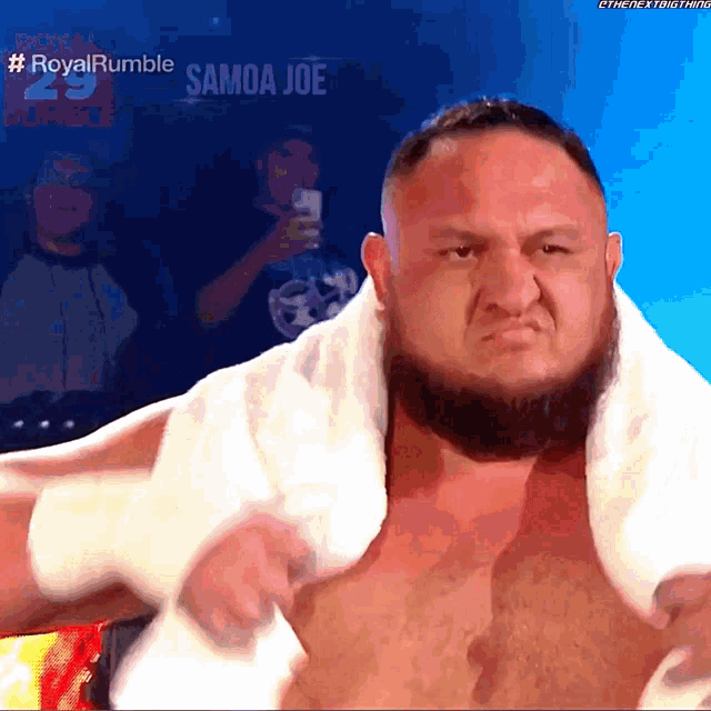 a shirtless wrestler with a towel around his neck and the hashtag #royalrumble samoa joe