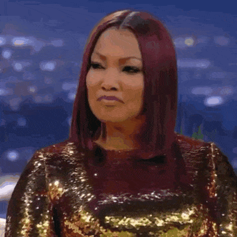 a woman wearing a black sequined dress and earrings is making a funny face .