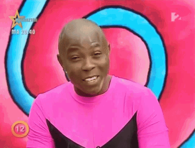 a man in a pink shirt with the number 12 on the bottom