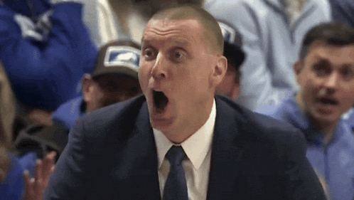 a man in a suit and tie making a surprised face