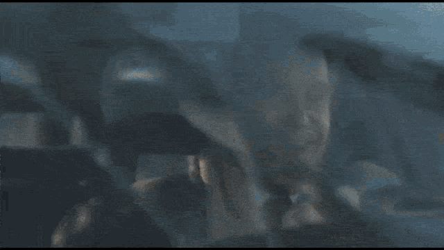 a blurry picture of a person in a car with a shark in the background