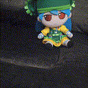a person is touching a stuffed doll with blue hair and green hat .