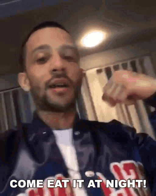 a man wearing a jacket that says come eat it at night on it
