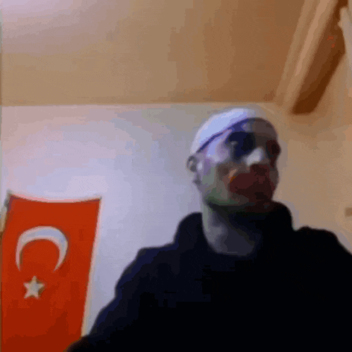 a man wearing sunglasses and a headband is standing in front of a turkey flag .