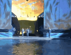a group of people are standing on a stage in front of a large screen with a sunset in the background