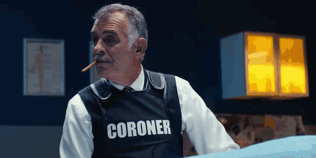 a man is wearing a vest that says coroner