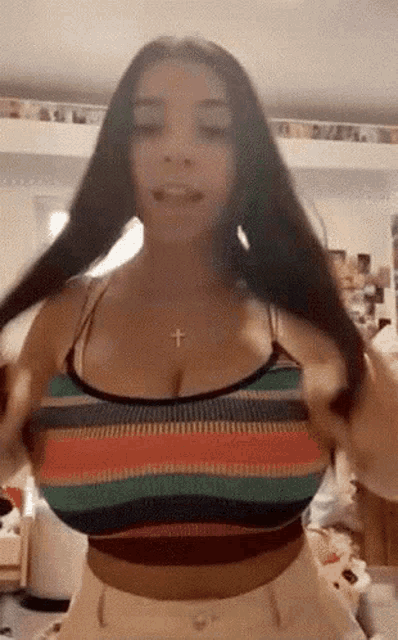 a woman with very large breasts is wearing a striped top and shorts .