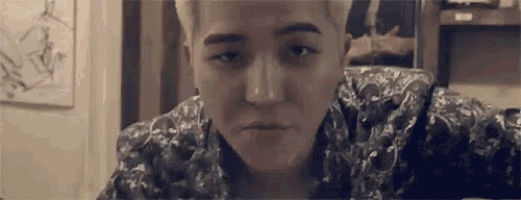 a close up of a man 's face with a floral shirt on looking at the camera .