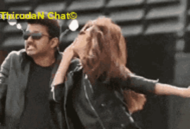 a man and a woman are standing next to each other with their arms outstretched .
