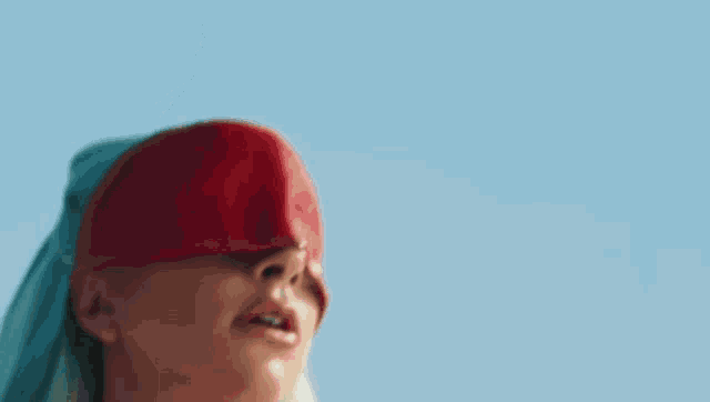 a woman covering her eyes with a red bandage